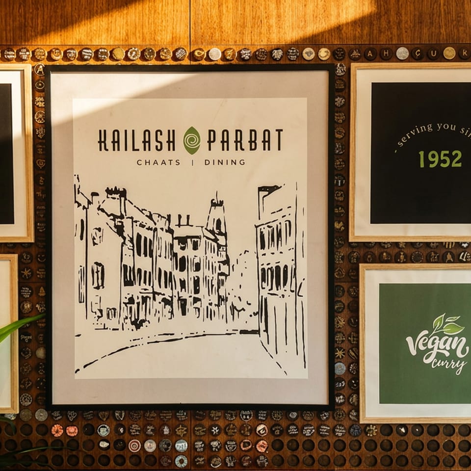 Restaurant wall with Kailash Parbat posters, including "Taste the Legend" and "Vegan curry".